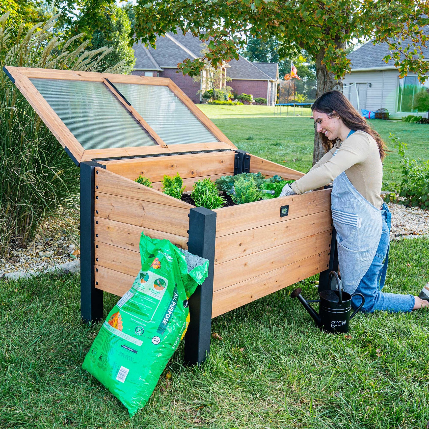 Backyard cold frame box serves as a mini greenhouse kit for starting an herb garden.