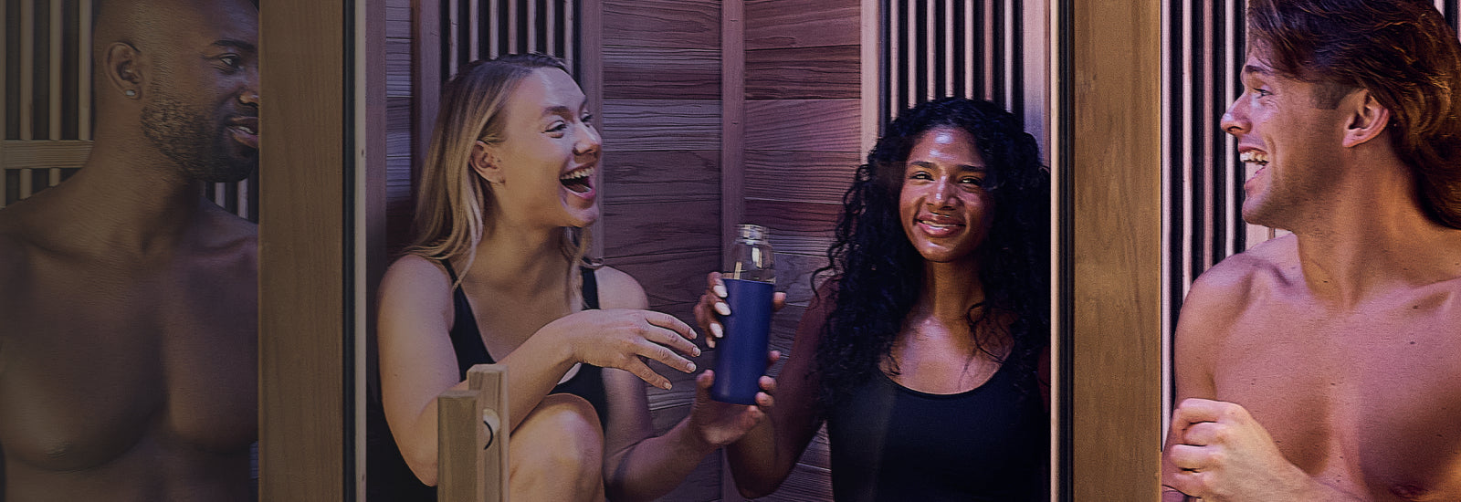 Two women in a steam room with one holding a blue bottle.