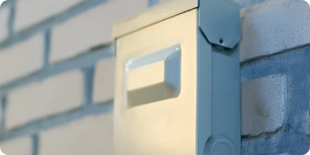 Metallic mailbox attached to a brick wall