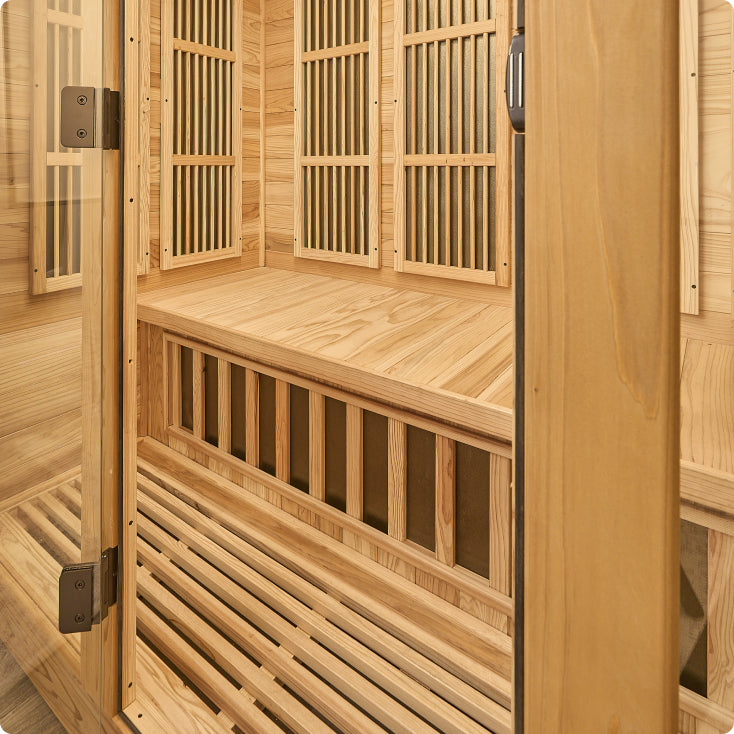 Wooden sauna with benches and a door open, showing interior design.