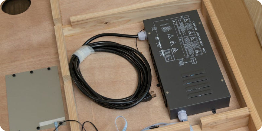 Electronic components on a wooden surface with a power supply and cable.