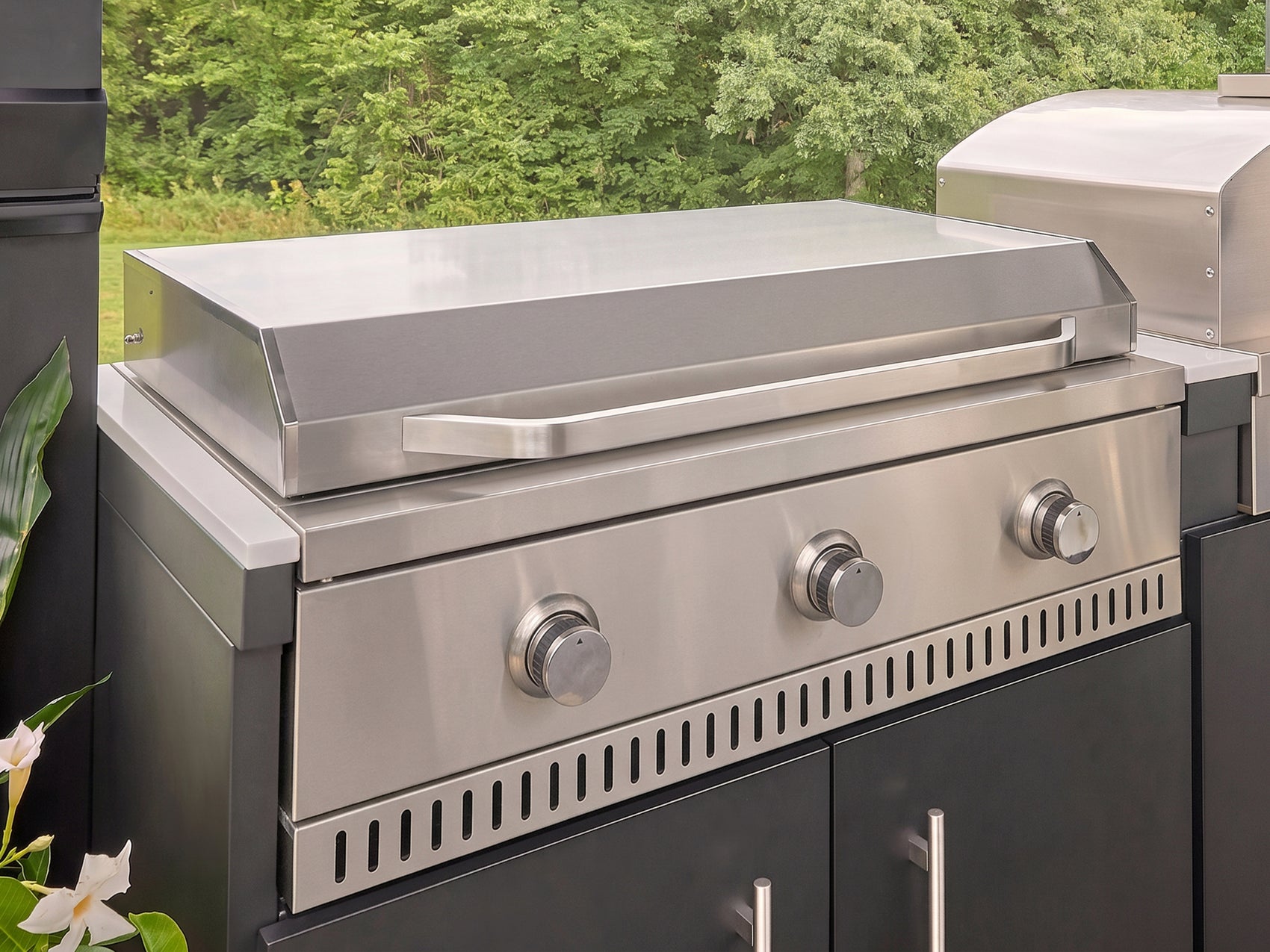 Stainless steel griddle with three control knobs built into the Langston galvanized steel kitchen.