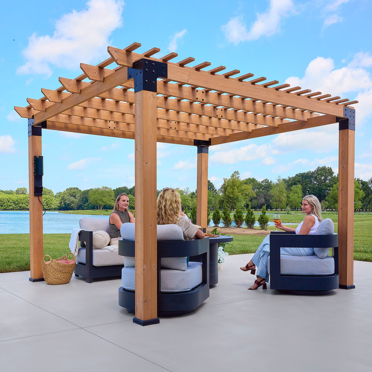 Open-slat purlin roof and cedar posts defining a freestanding outdoor pergola over a paved patio.