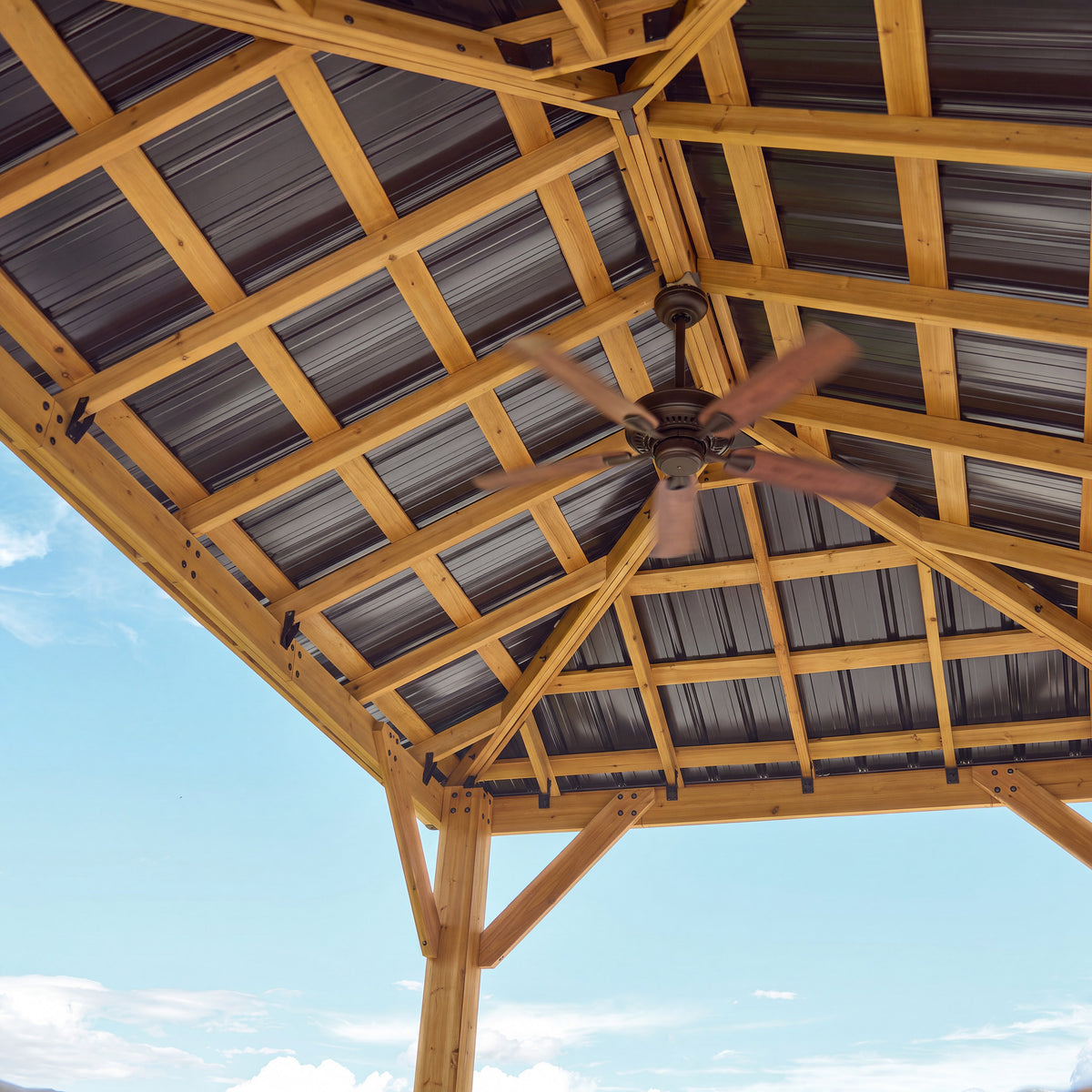 Ceiling fan bracket mounted to the steel roof structure of a cedar outdoor gazebo.