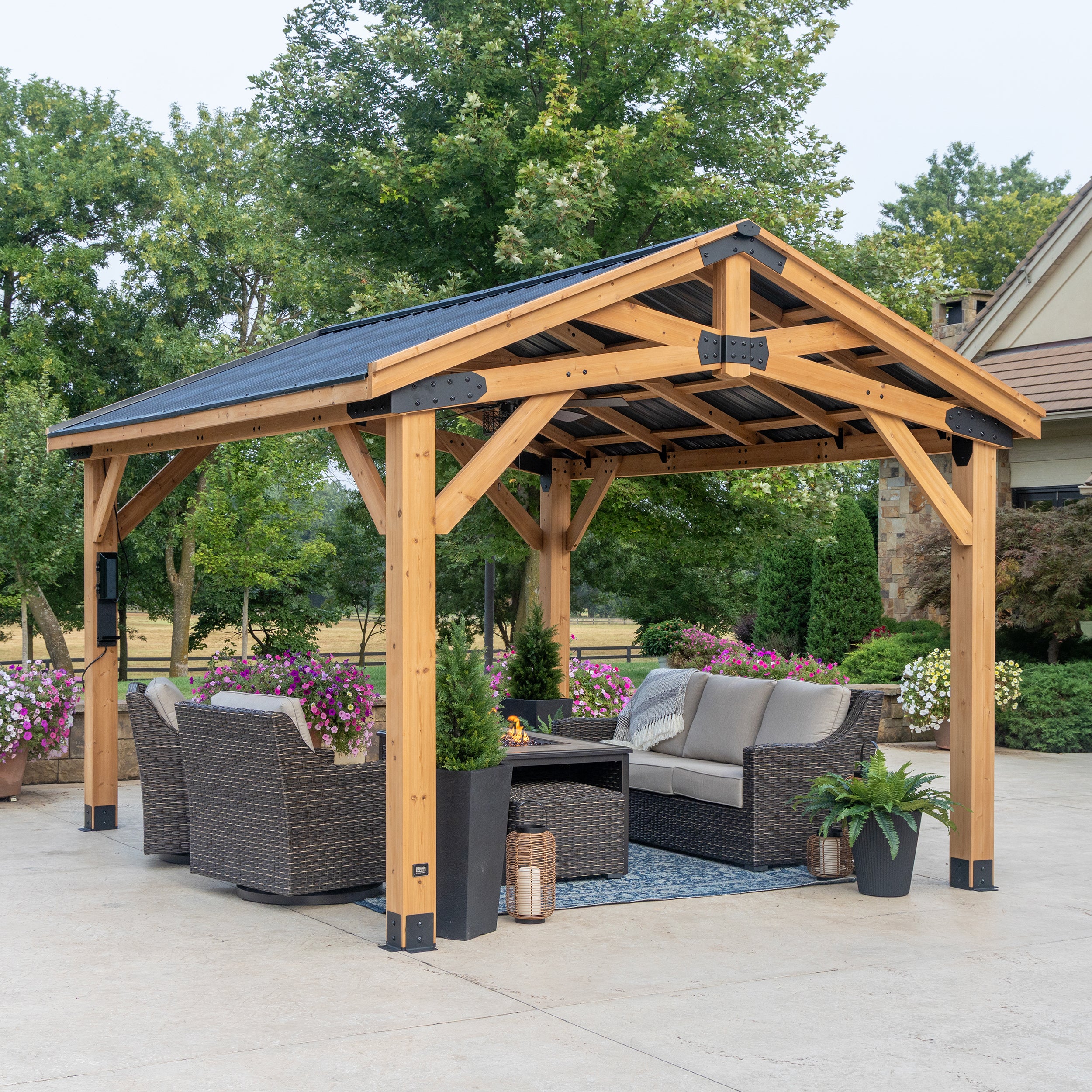 Backyard Discovery cedar gazebo with powder-coated steel roof and metal brackets on patio with outdoor furniture.