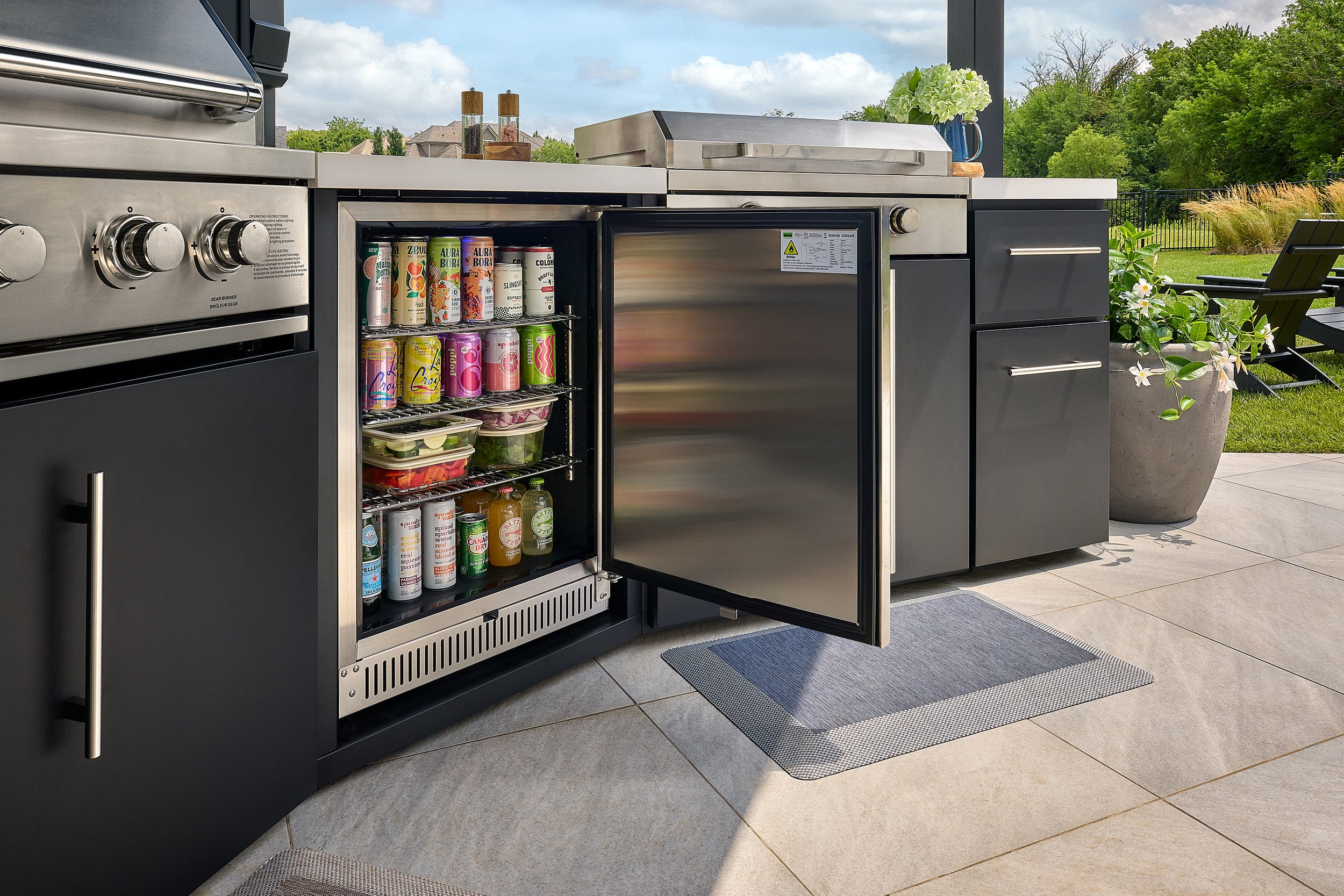 Black protective cover over the pizza oven on the Edgemont Cove Outdoor Kitchen, covering the chimney and body