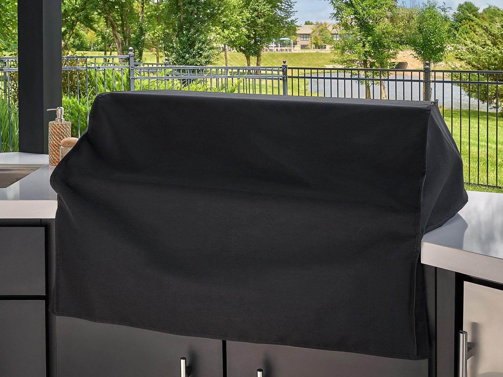Edgemont Cove Outdoor Kitchen flat-top griddle with burgers, buns, and vegetables cooking on the stainless steel surface