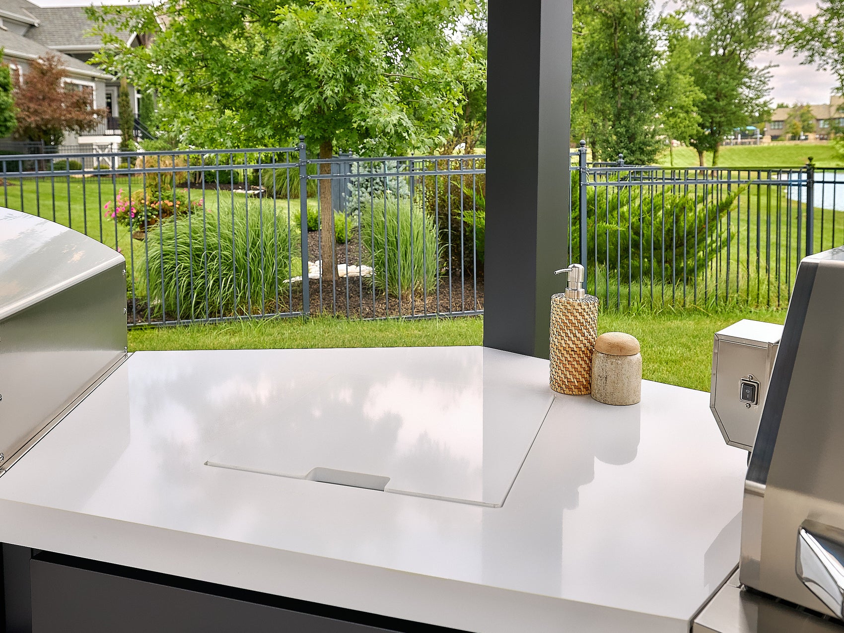Edgemont Cove Outdoor Kitchen post-mounted paper towel holder with roll installed, sink and soap dispenser visible on countertop below