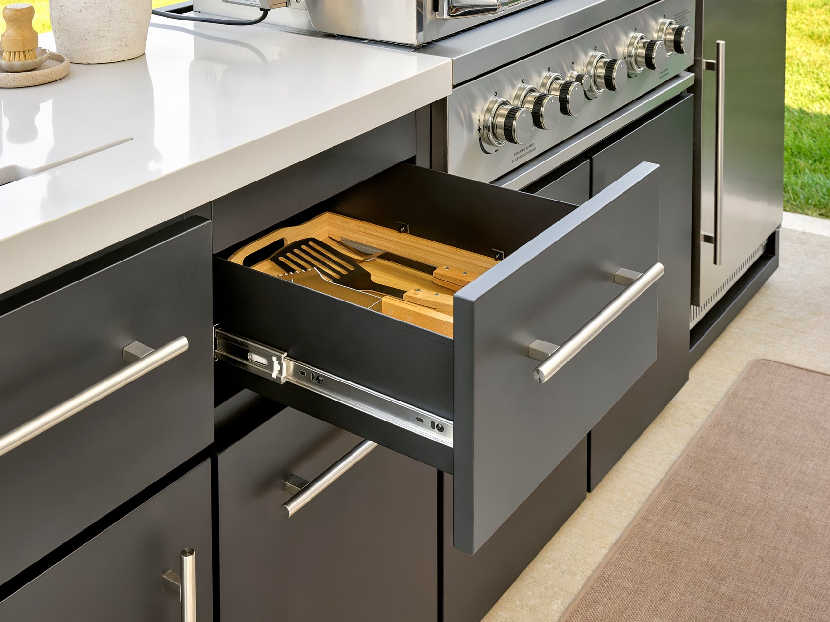 Open drawer with bamboo cutlery organizer providing Emory kitchen storage in cabinet with stainless steel hardware.