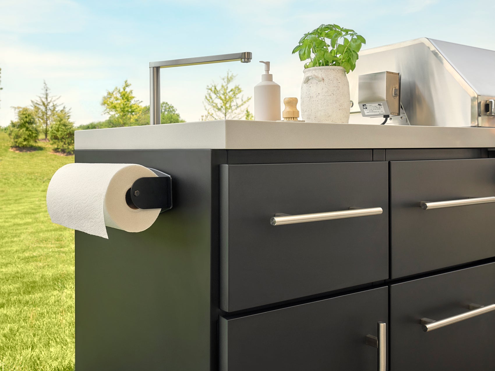 Emory modern outdoor kitchen with charcoal steel cabinetry, paper towel holder, sink with modern faucet.