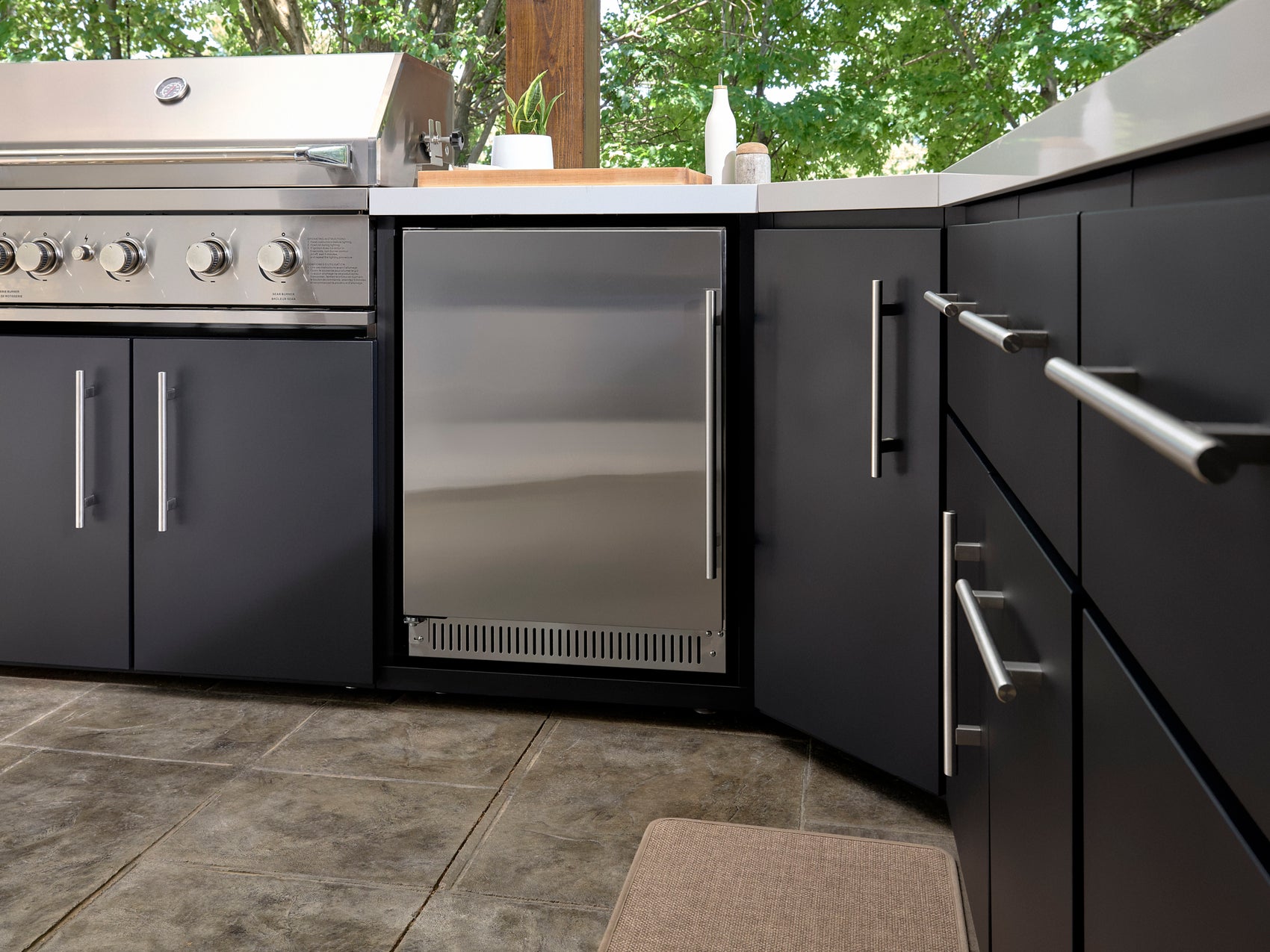 Built-in beverage cooler with glass door and stainless steel handle in dark gray Emory outdoor kitchen cabinet.