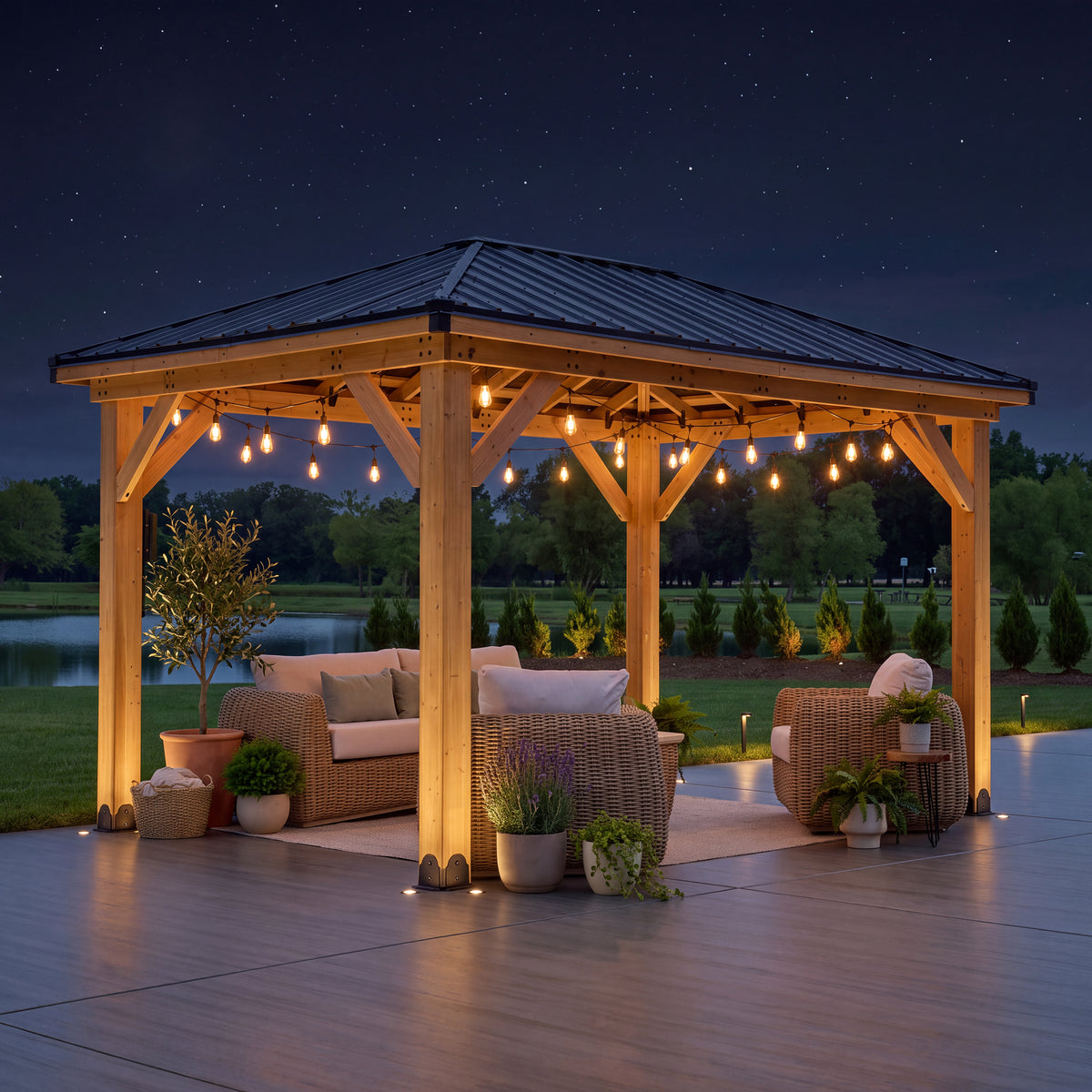 Hardtop gazebo lit by string lights at night, with wicker seating beneath its black steel hip roof.