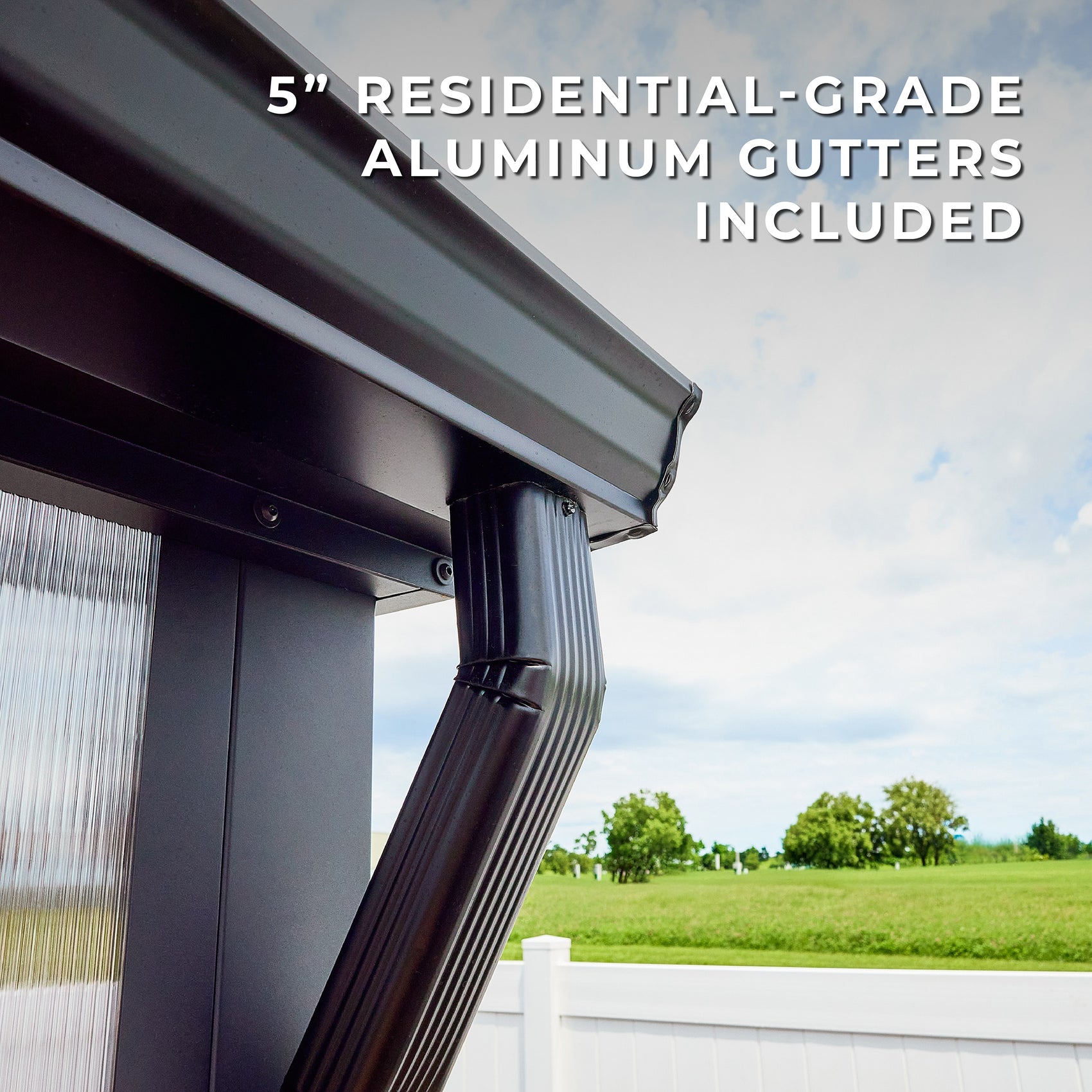Residential-grade aluminum gutters with downspouts channel rainwater off the peak roof of the Larkspur metal greenhouse.