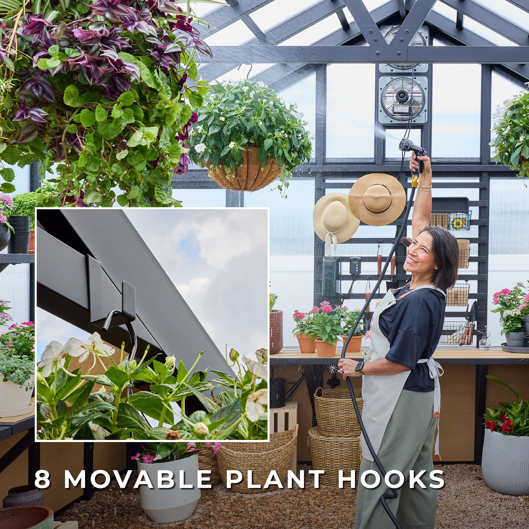 Woman watering hanging baskets inside the Larkspur metal and aluminum greenhouse kit.