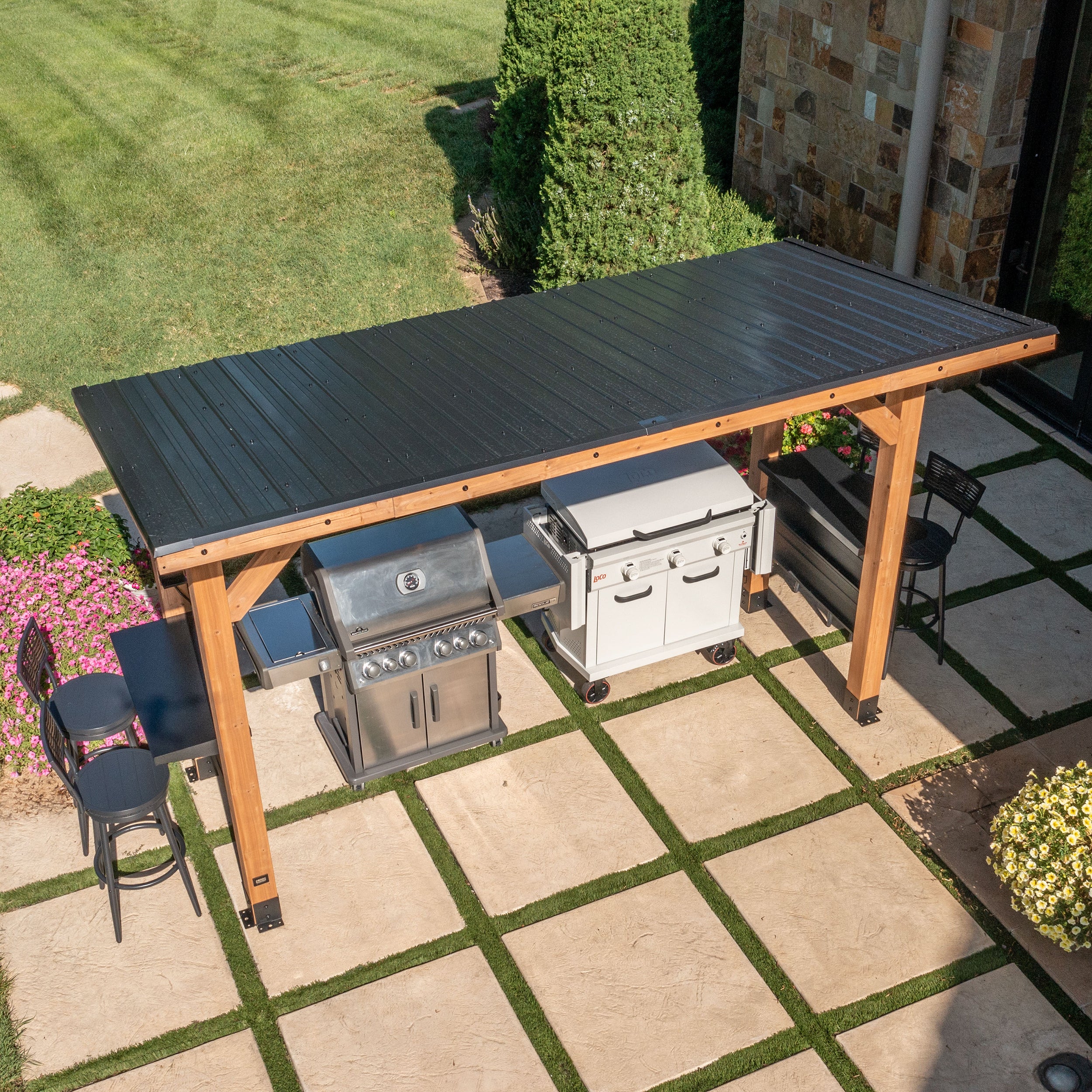 Aerial view of cedar grill gazebo with steel hardtop roof sheltering outdoor grill on backyard patio.