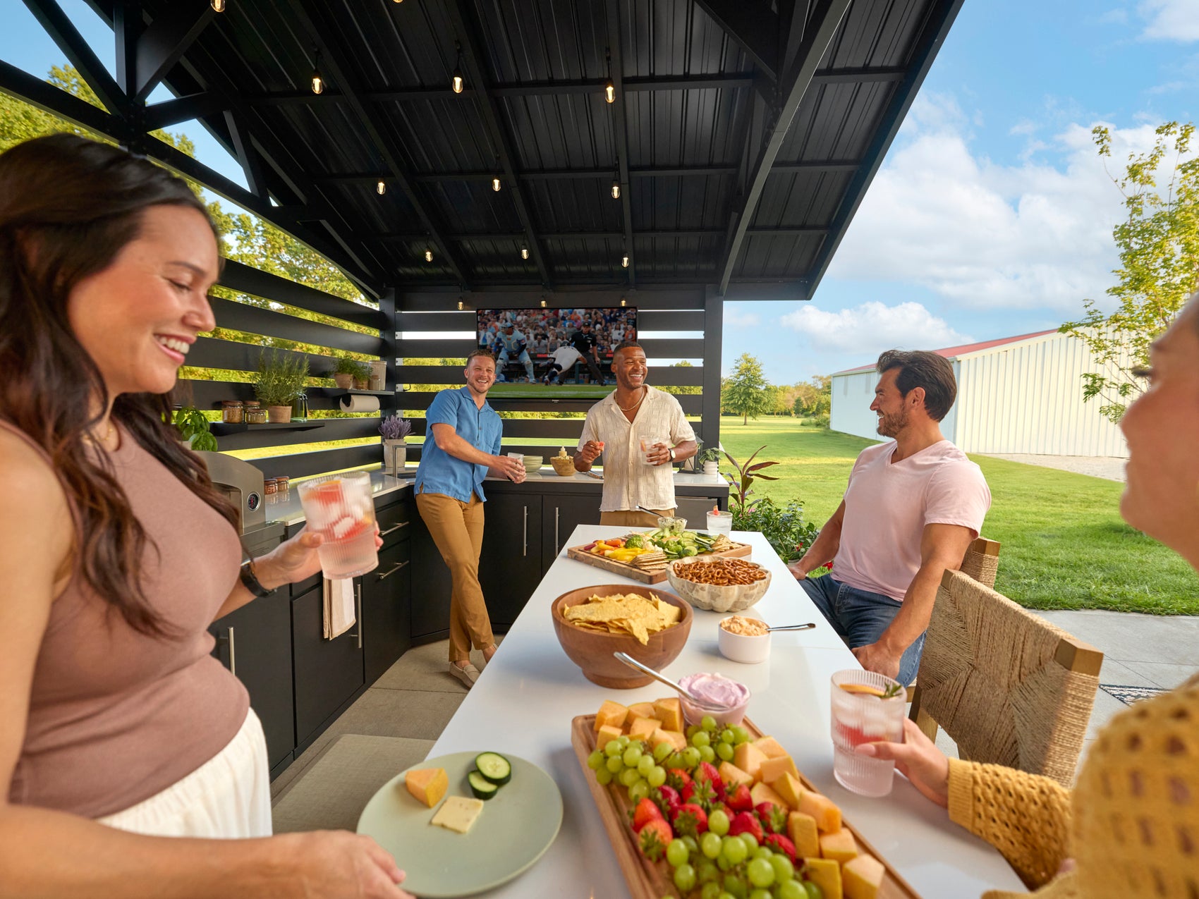 Langston outdoor grill kitchen with cabinets and white countertop under modern pavilion at backyard gathering.