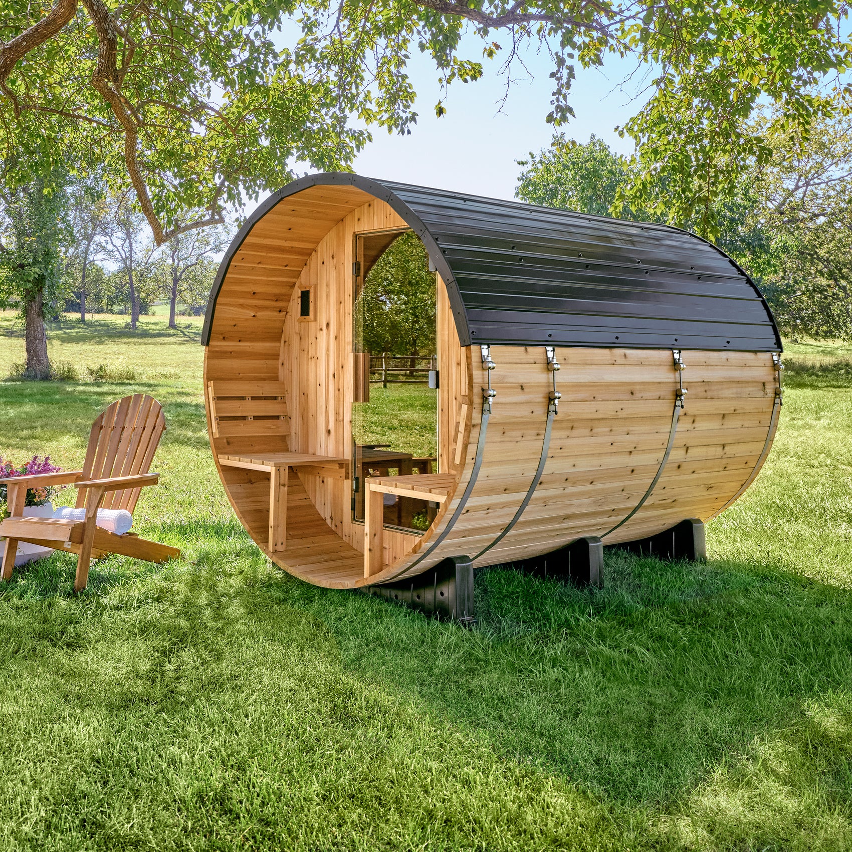 Backyard Discovery Paxton 4-6 person barrel sauna with front porch and cedar bench seating in sunny setting