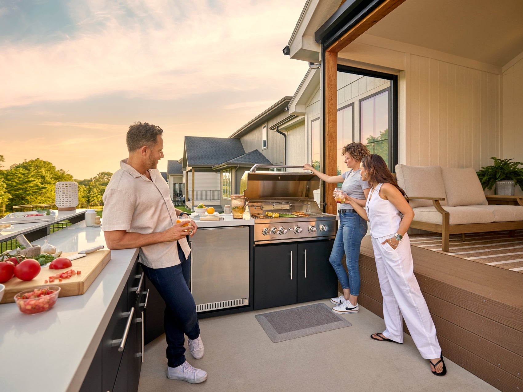 Emory prefab outdoor kitchen with black cabinets, built-in grill, and engineered stone countertop on covered patio.