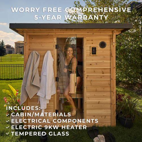 Two women enjoying outdoor home sauna session with robes and glass door open to backyard setting