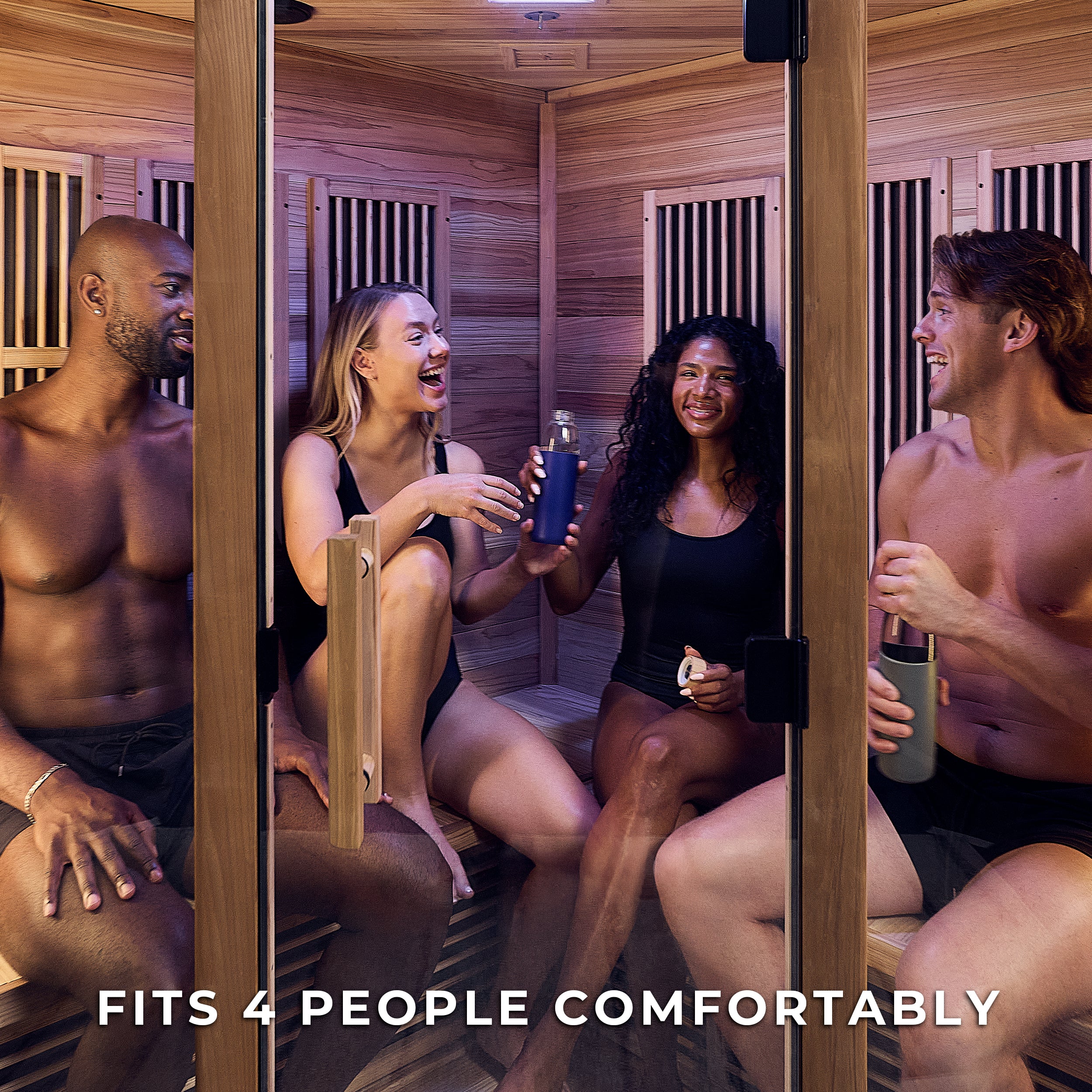 Four friends relaxing inside Rylan 4 person infrared corner home sauna with heating panels and cedar walls