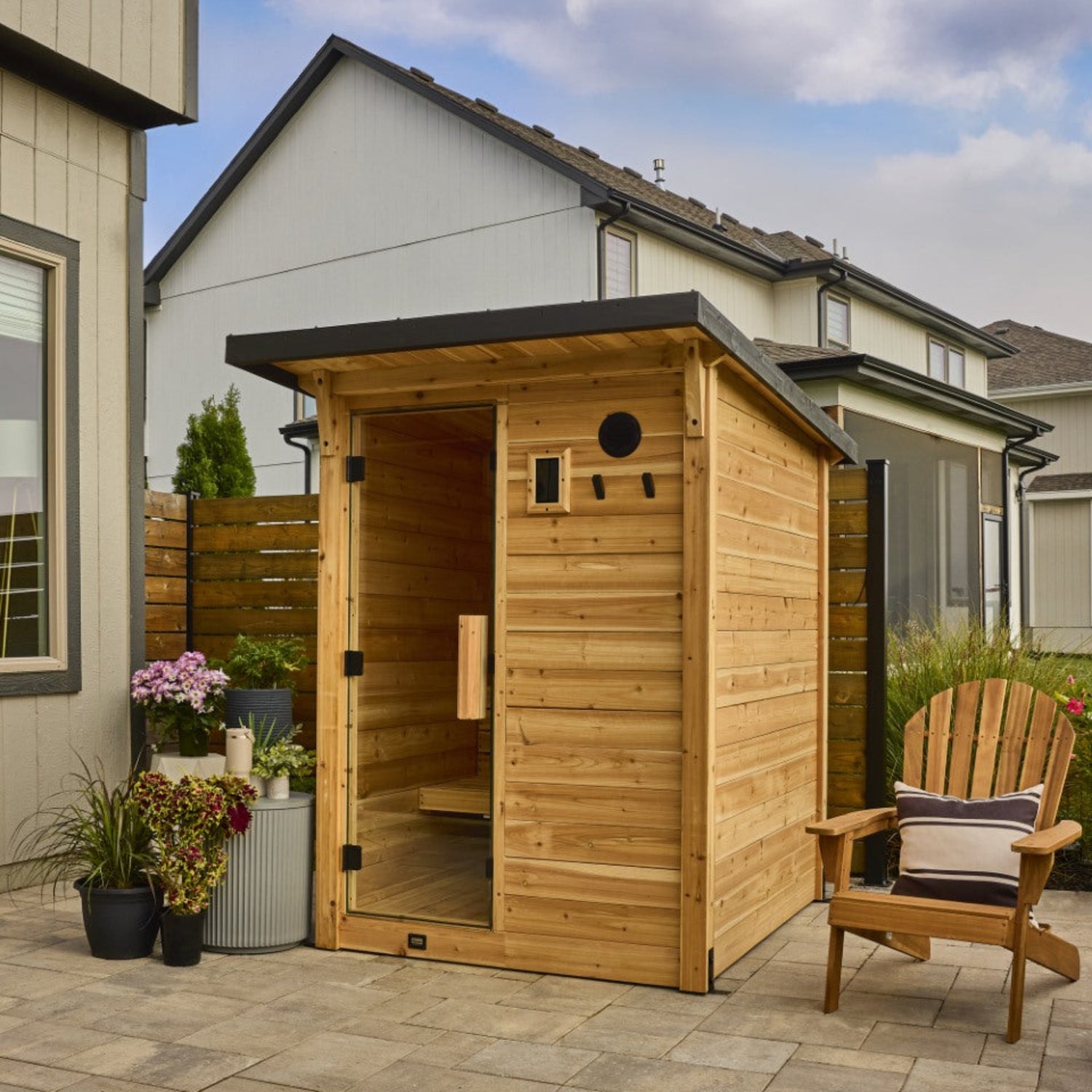 Backyard Discovery Henley 2-4 person outdoor cabin cedar sauna with steel roof on stone patio in backyard