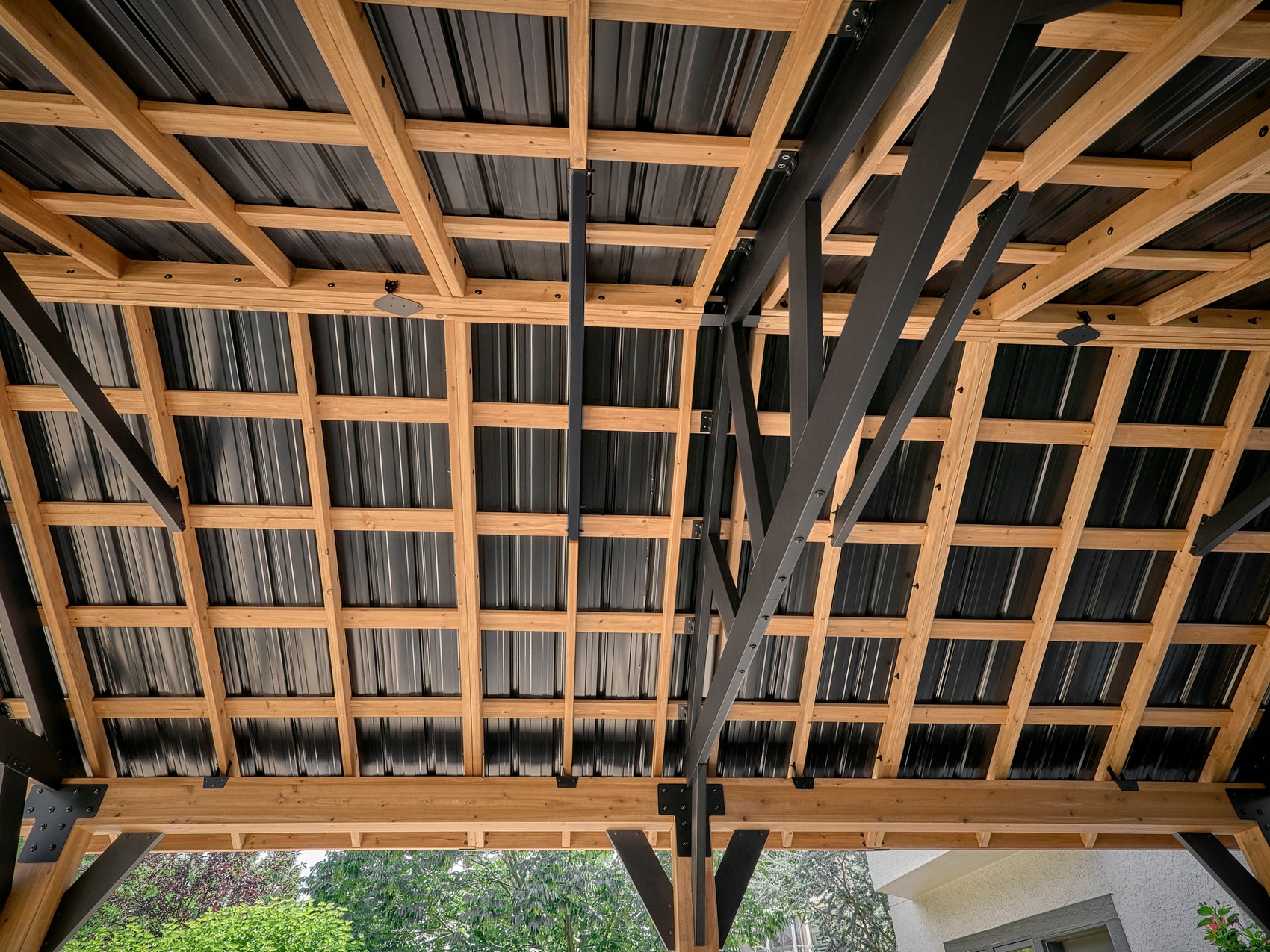 Interior view of Range Outdoor Living Lodge gazebo roof with exposed steel beams, wood framing.