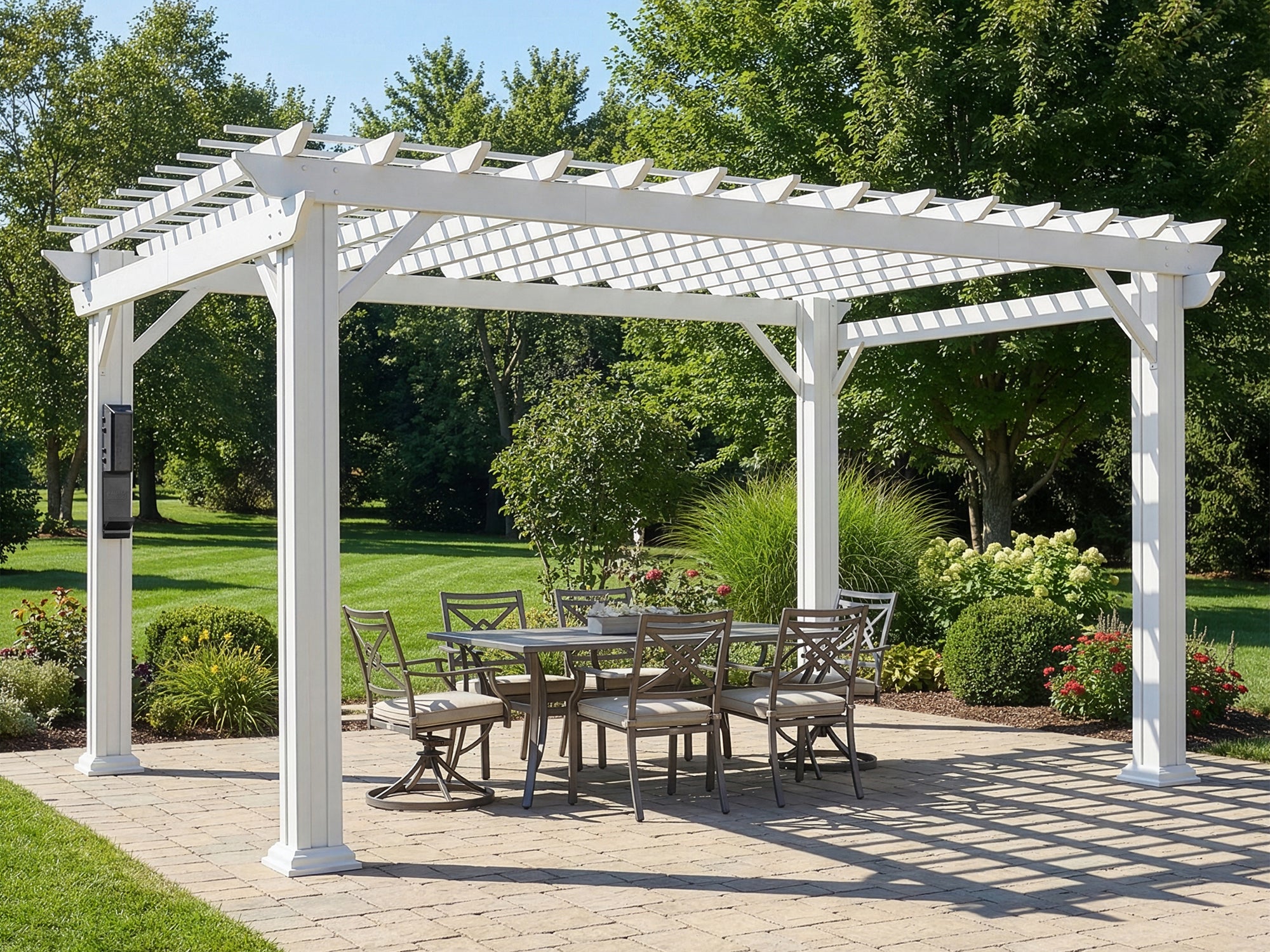 White pergola with open trellis roof over outdoor dining area in landscaped yard with brick pavers and green lawn.