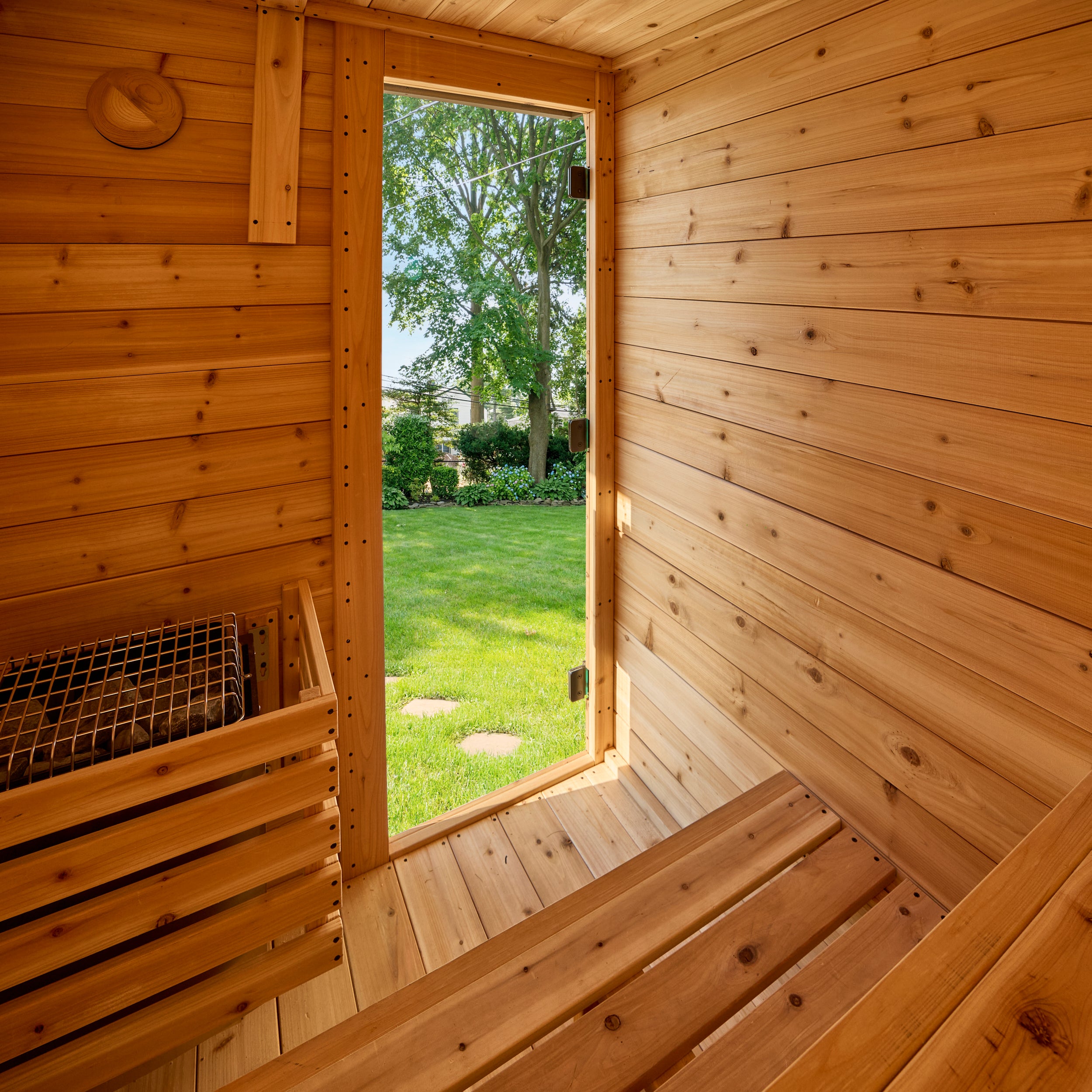 Interior of the Henley 2-4 person outdoor cabin cedar sauna with electric stone heater for dry sauna sessions