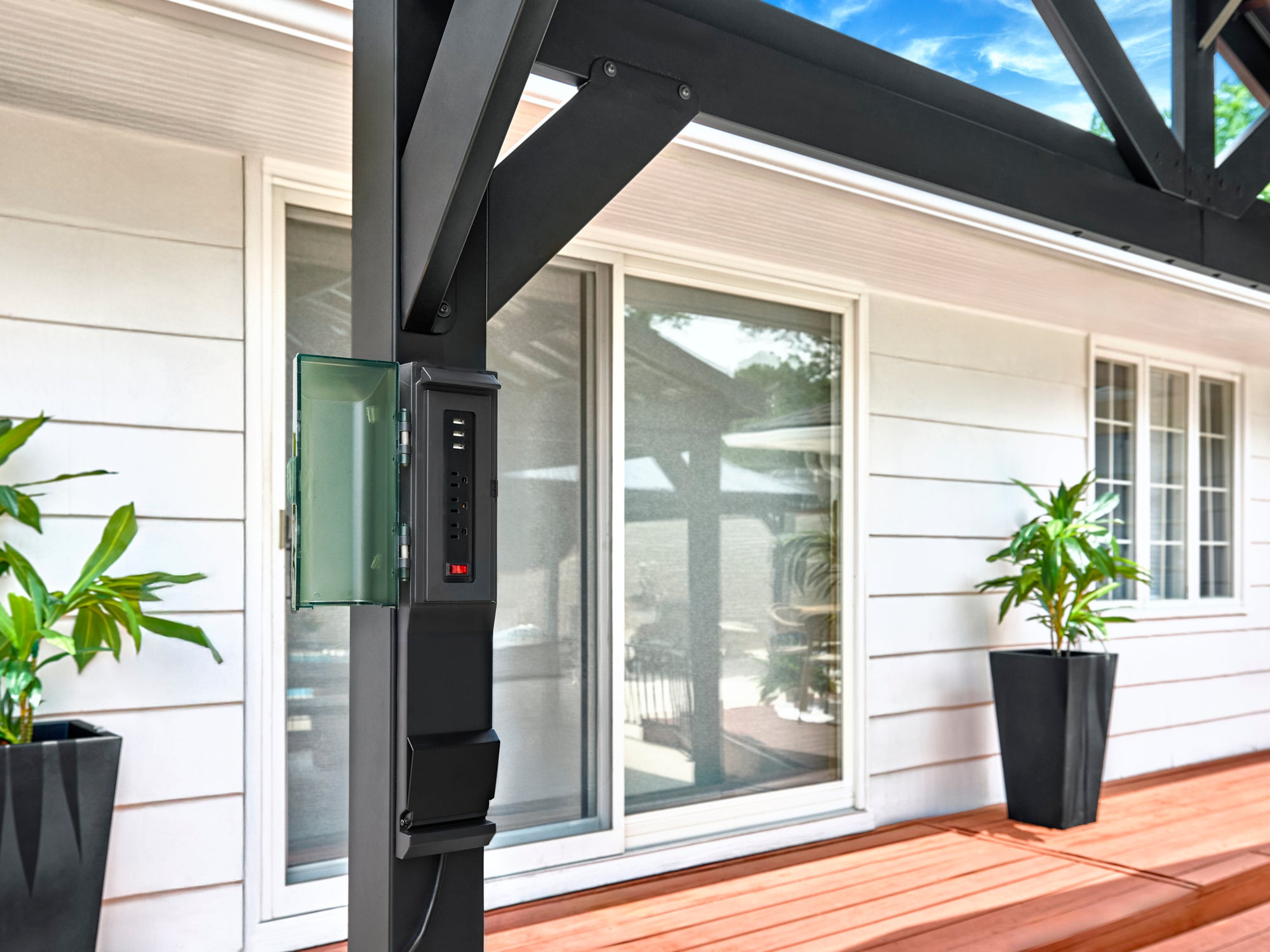 Electrical outlet box mounted on black steel post of Lancaster metal gazebo with open cover revealing multiple ports.