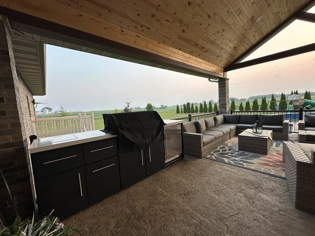 Black steel backyard shade structure with trellis roof covering Emory outdoor kitchen and lounge area.
