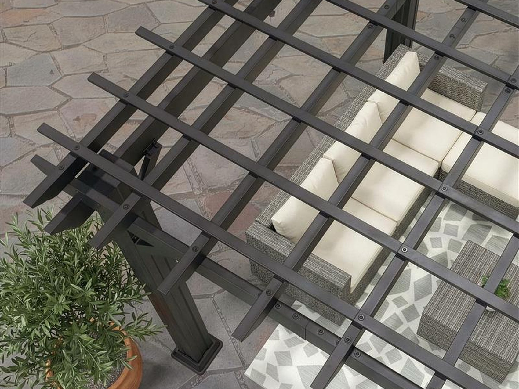 Black Stratford steel pergola with open lattice roof over outdoor seating area with cream cushions and patterned pillows.