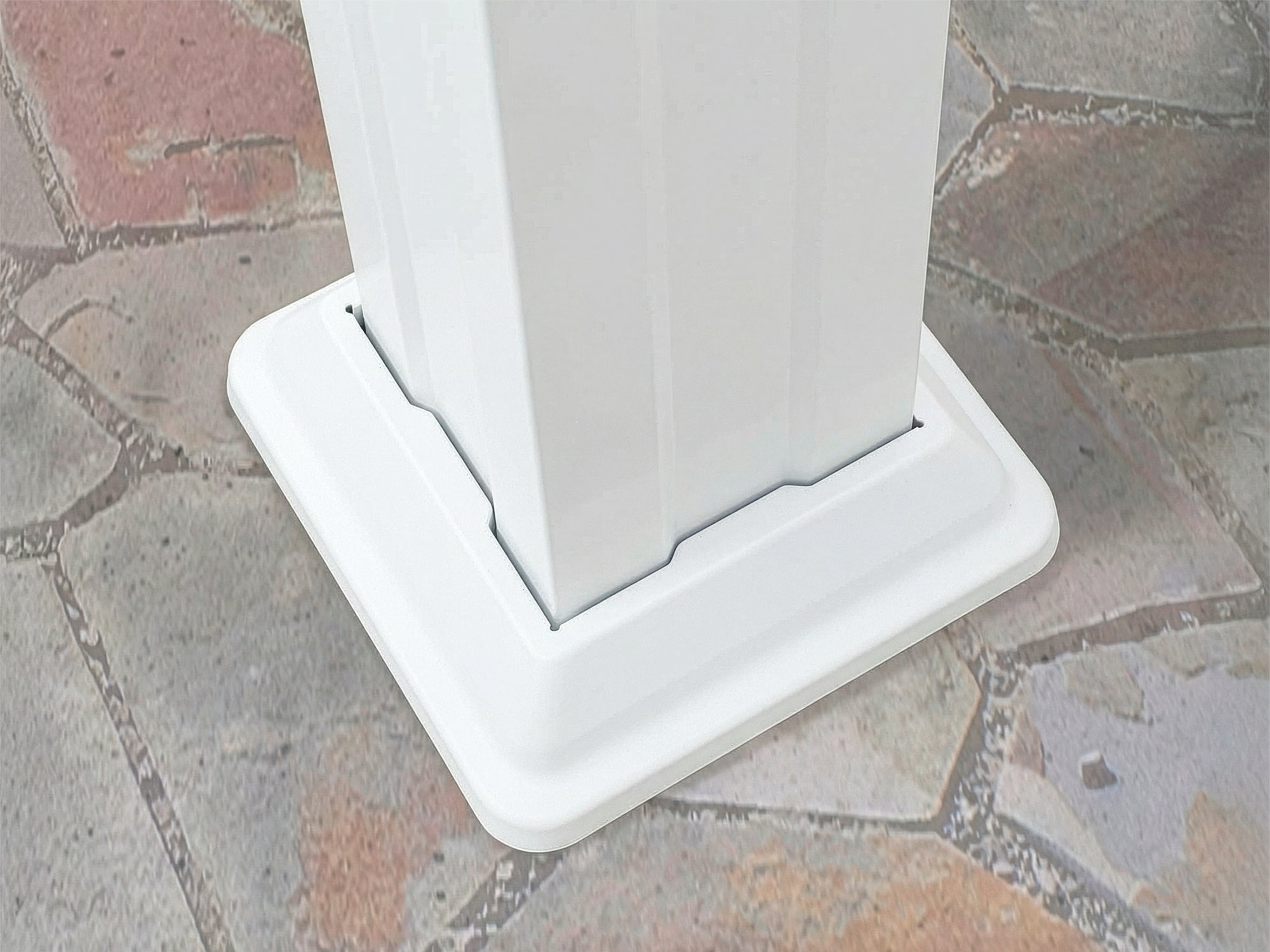 White powder-coated steel base plate Stratford securing pergola beam to brick paver patio surface.