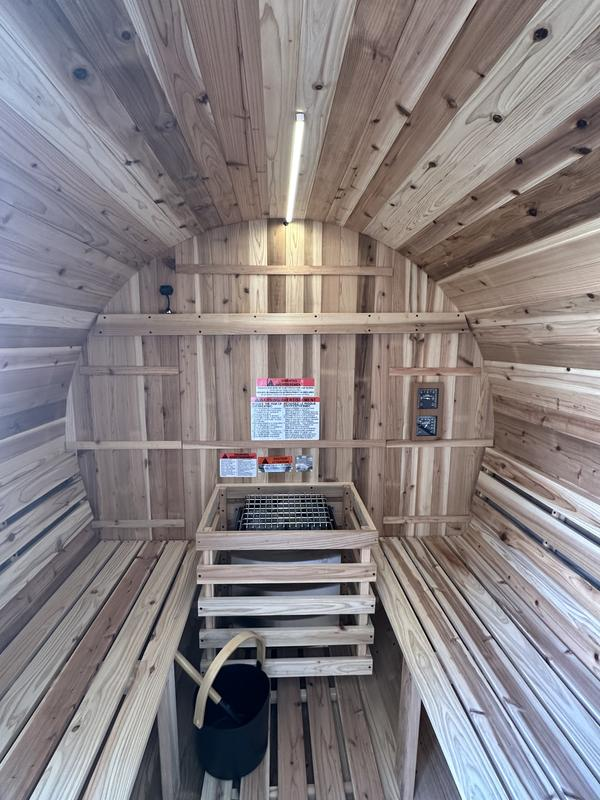 Wooden interior of a sauna with wooden benches and shelves.