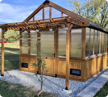 Bellerose wooden greenhouse kit with polycarbonate panels on a sunny day.