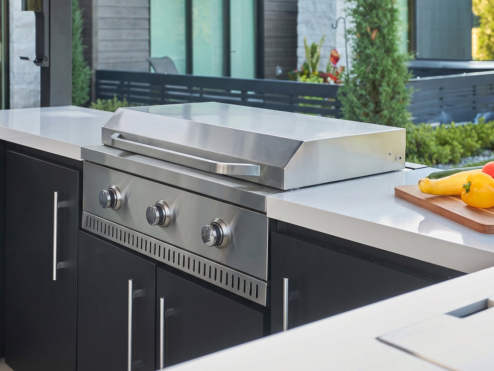 Edgemont Bay flat top griddle with stainless steel cooktop built into a galvanized steel outdoor kitchen.