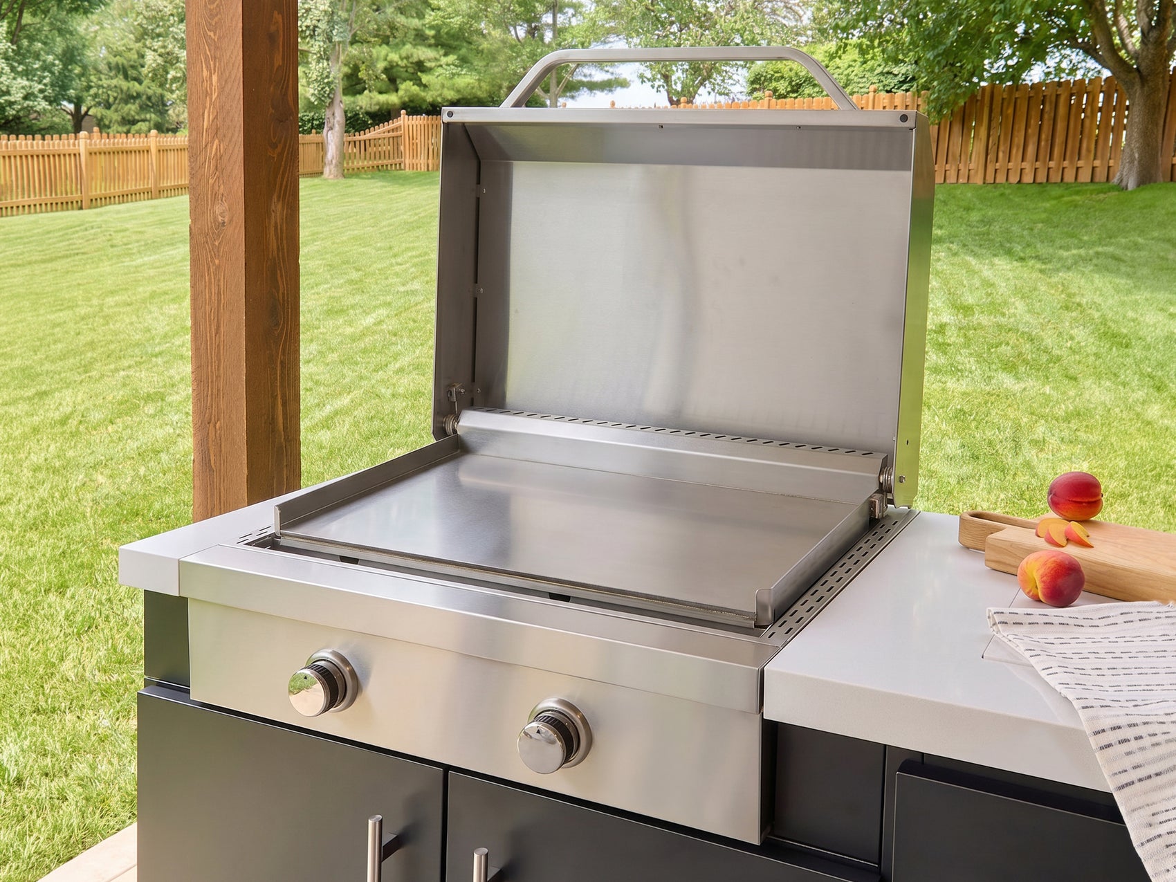 Outdoor griddle made from stainless steel with the lid open on the galvanized steel Emory kitchen base.