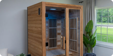 Wooden sauna in a room with a window showing greenery outside
