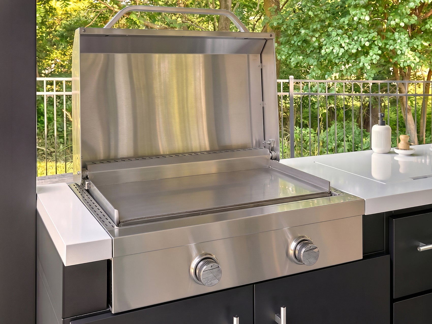 Outdoor griddle made from stainless steel with the lid open in the Lancaster Galley backyard kitchen.