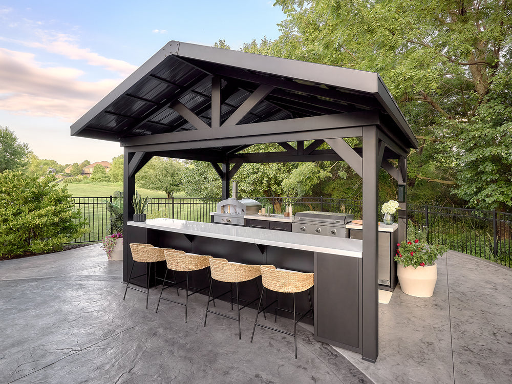Lancaster Galley outdoor kitchen with galvanized steel roof shelters a pizza oven, stainless steel griddle.