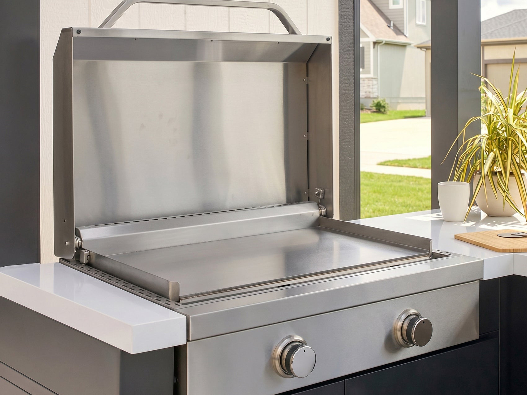Outdoor griddle made from stainless steel with the lid open built into the Lancaster L-Shape kitchen.