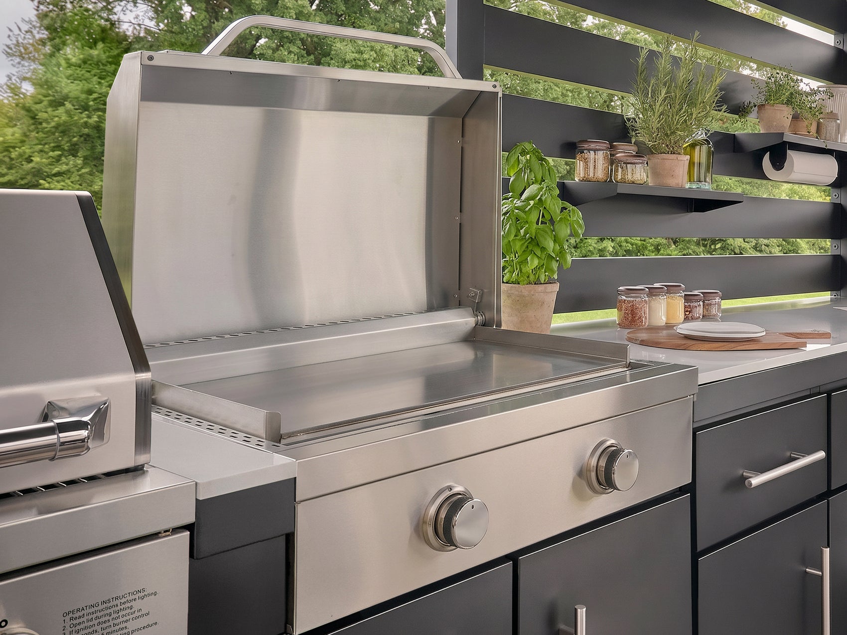 Outdoor griddle made from stainless steel with the lid open built into the Langston galvanized steel kitchen.