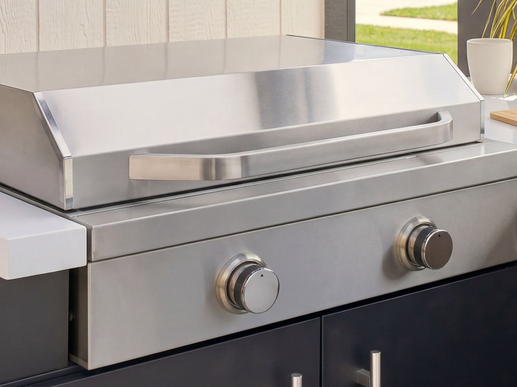 Stainless steel grill with control knobs on an outdoor setting