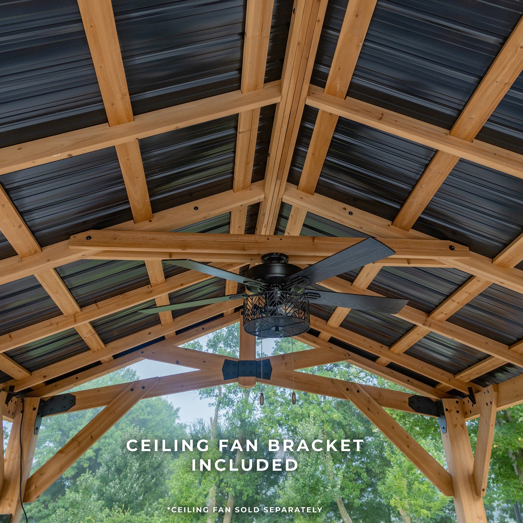 Ceiling fan mounting bracket attached to exposed wood beams and metal roof inside hardtop gazebo with cathedral-style vaulted ceiling.