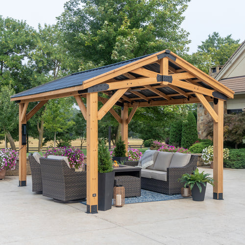 Backyard Discovery cedar gazebo with powder-coated steel roof and metal brackets on patio with outdoor furniture.
