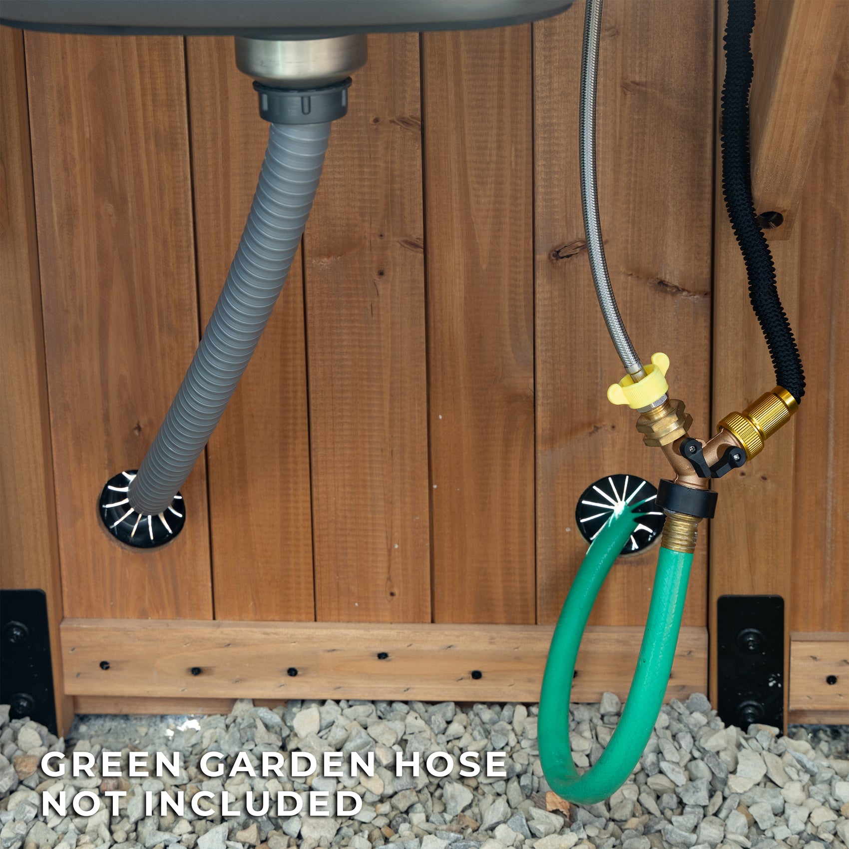 The interior hose hookup and drain hose exit through the cedar base of the Savannah greenhouse kit.