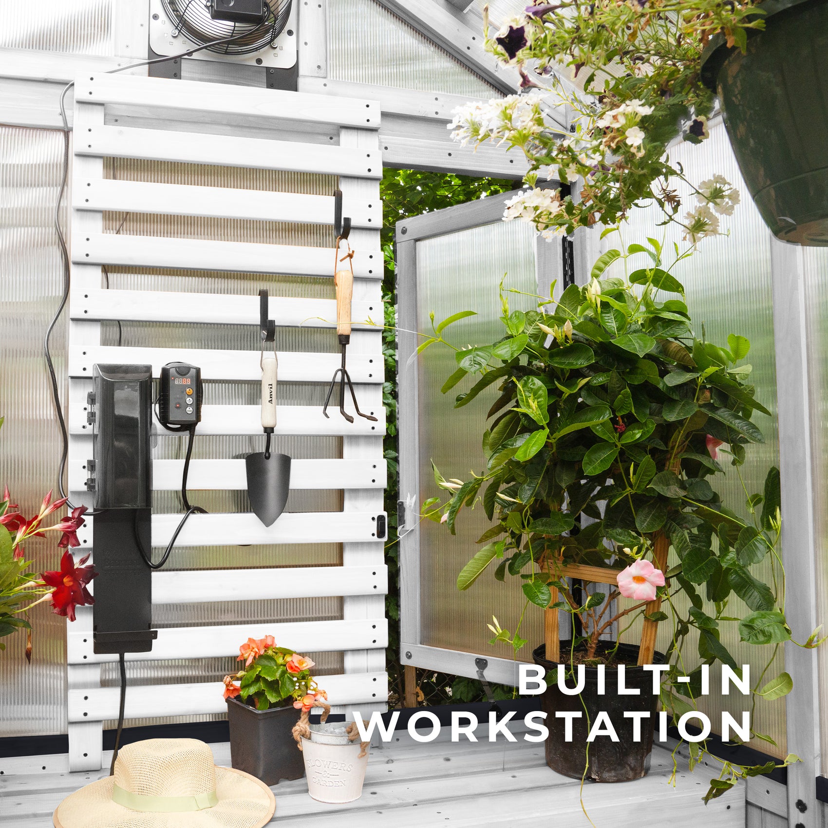 A slat wall inside the White Bellerose greenhouse holds hand tools beside a thermostat-activated exhaust fan.