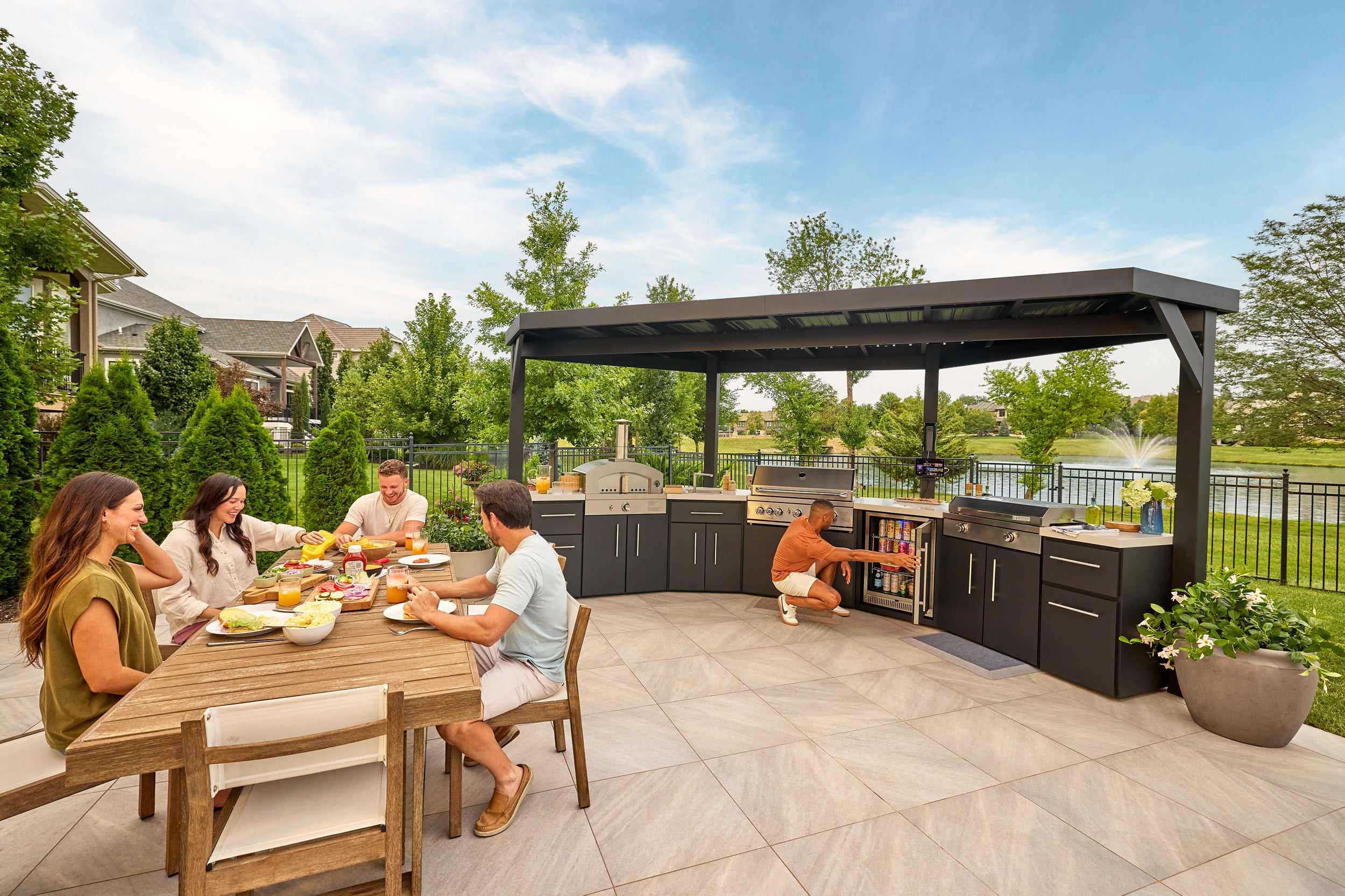Edgemont Cove Outdoor Kitchen double-door lower cabinet beneath grill open, showing two shelves with woven storage baskets