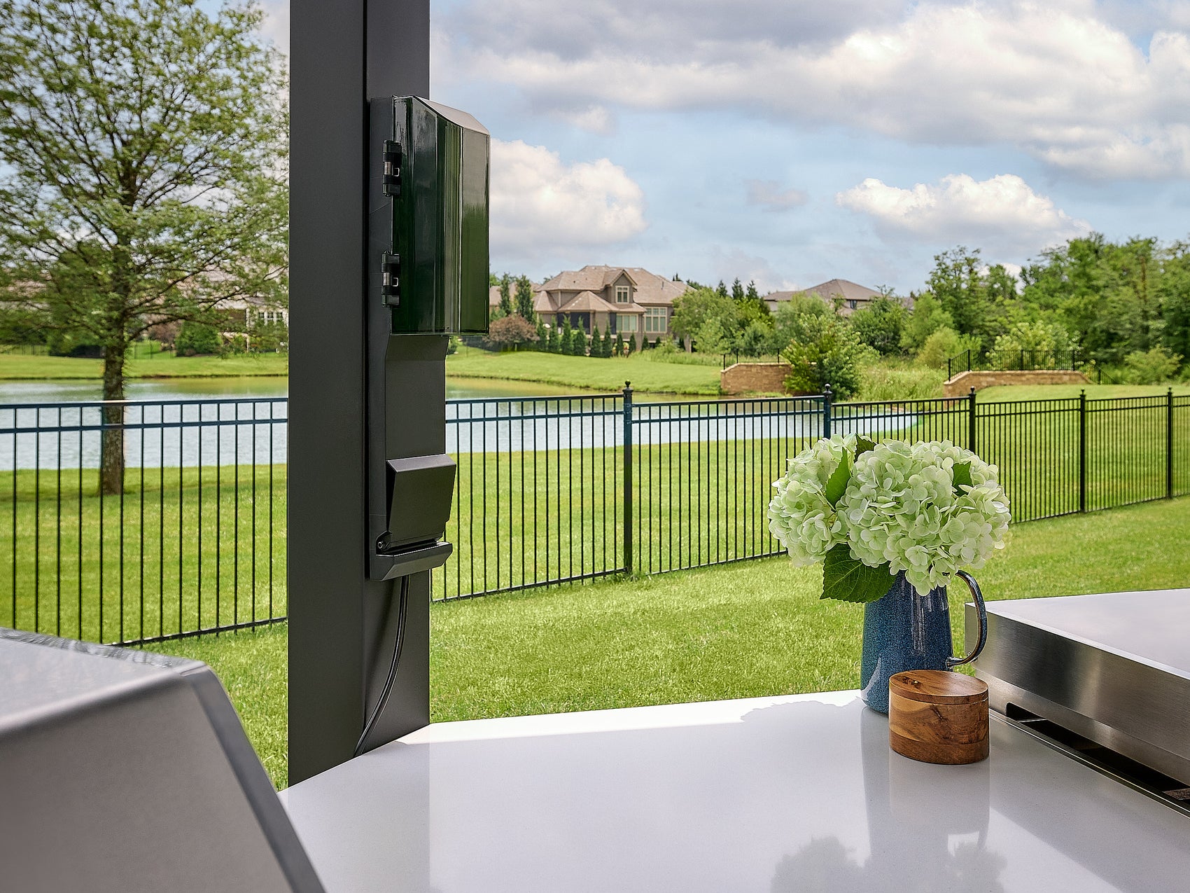 Black protective cover over the built-in grill section of the Edgemont Cove Outdoor Kitchen