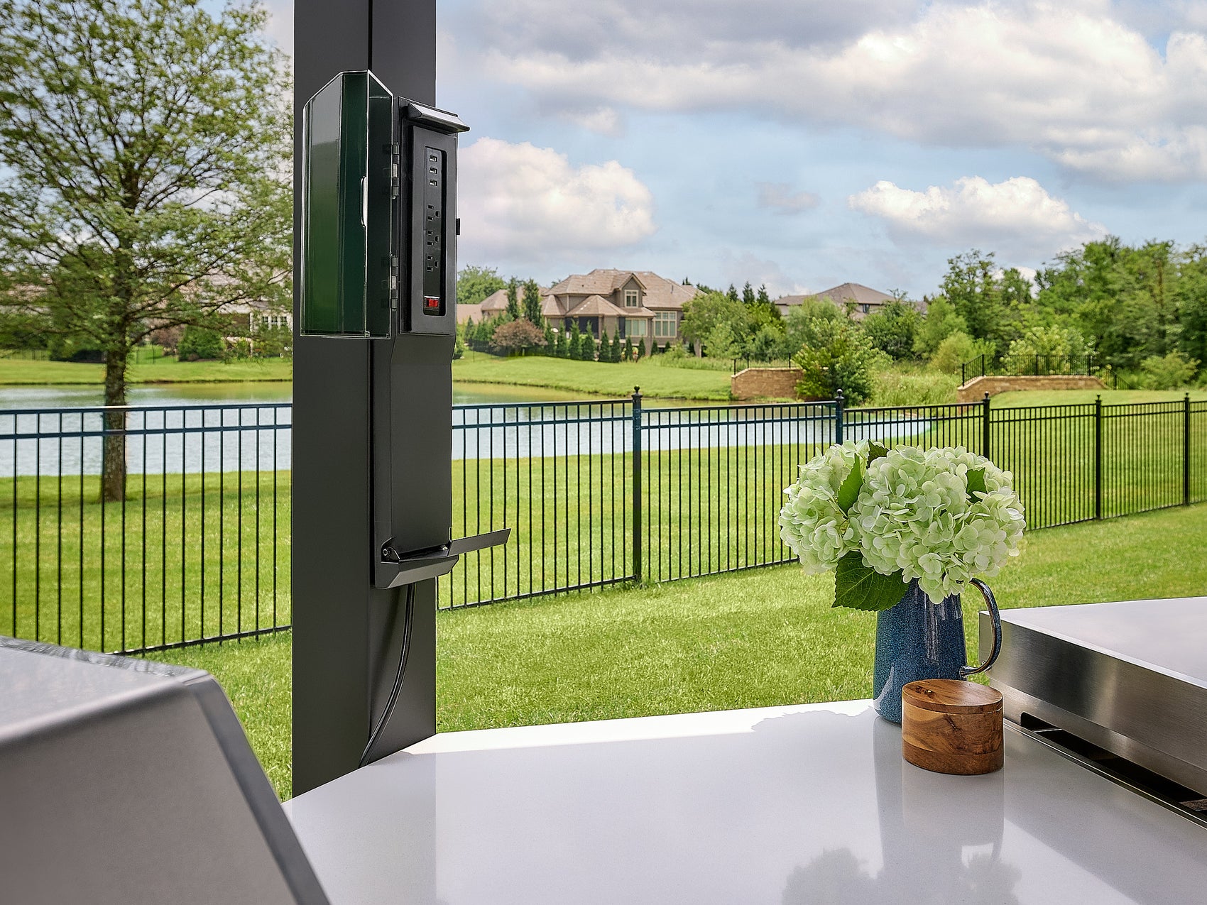 Edgemont Cove Outdoor Kitchen stainless steel built-in gas grill with lid open, grilling vegetable skewers and asparagus