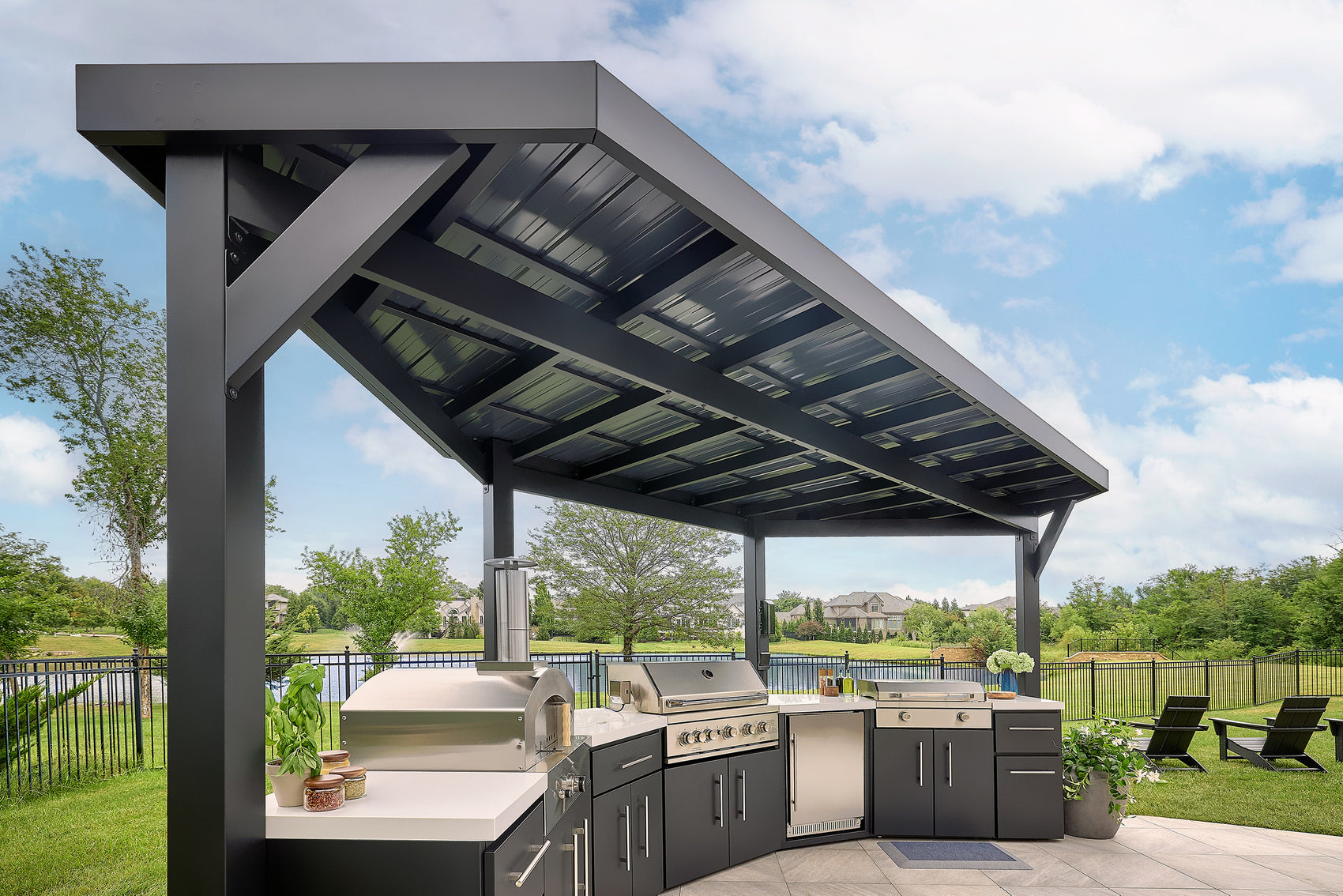 Edgemont Cove Outdoor Kitchen stainless steel drop-in sink with faucet running water, set into white engineered stone countertop